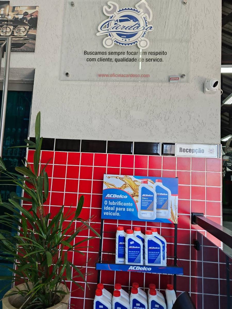 Recepção da oficina com a placa dos valores da casa e produtos ACDelco expostos.